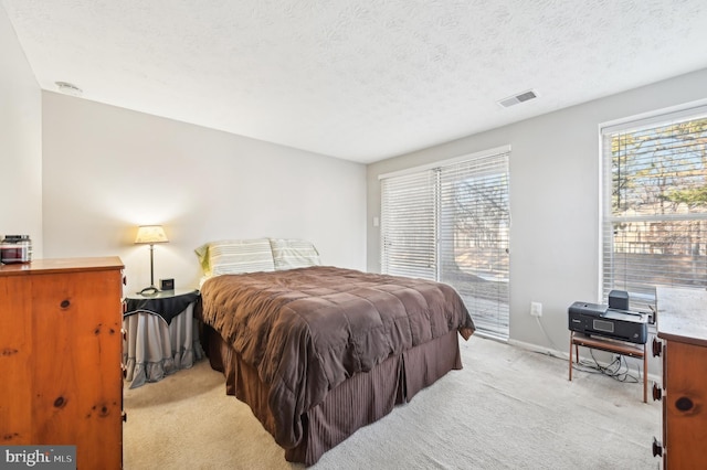 bedroom featuring access to exterior, visible vents, baseboards, light carpet, and a textured ceiling