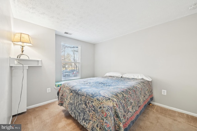 bedroom featuring visible vents, a textured ceiling, baseboards, and carpet floors