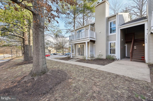 view of property exterior featuring a chimney and a balcony