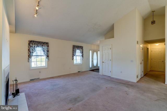 unfurnished living room with visible vents, a fireplace with flush hearth, carpet, and baseboards