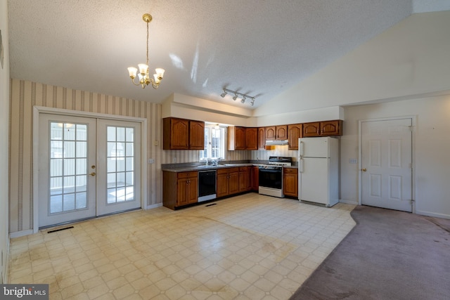 kitchen featuring wallpapered walls, black dishwasher, freestanding refrigerator, gas stove, and a sink