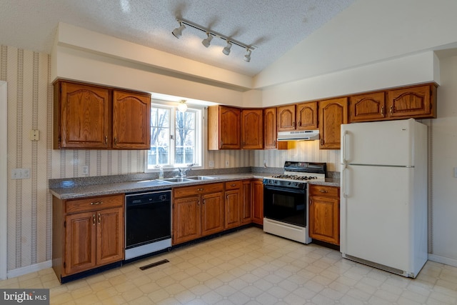 kitchen with under cabinet range hood, black dishwasher, freestanding refrigerator, range with gas cooktop, and wallpapered walls