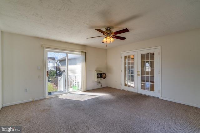 carpeted spare room featuring heating unit, french doors, baseboards, and a textured ceiling