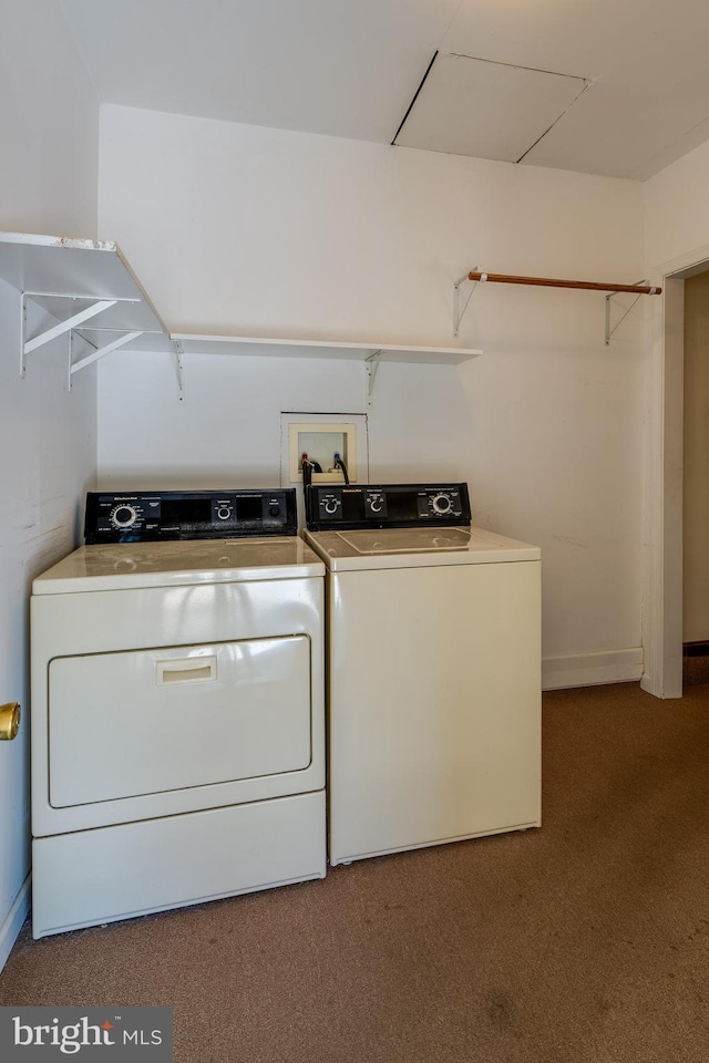 clothes washing area featuring laundry area, carpet flooring, baseboards, and washing machine and clothes dryer