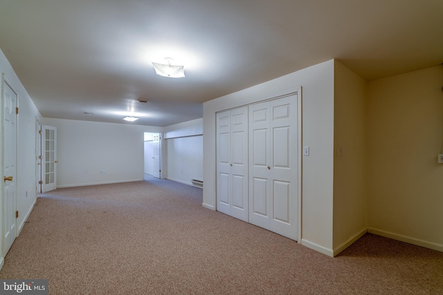 below grade area with a baseboard radiator, baseboards, and carpet floors