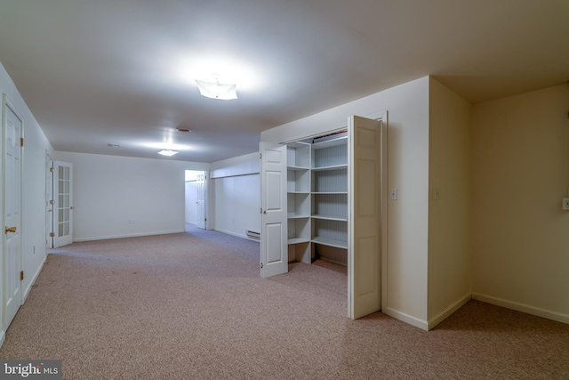 basement featuring carpet flooring and baseboards