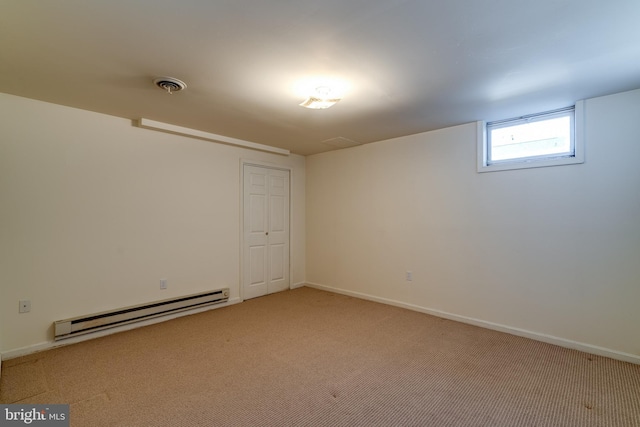 spare room with light carpet, visible vents, baseboards, and a baseboard radiator