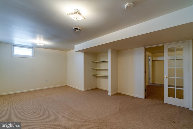 basement with visible vents, baseboards, and carpet