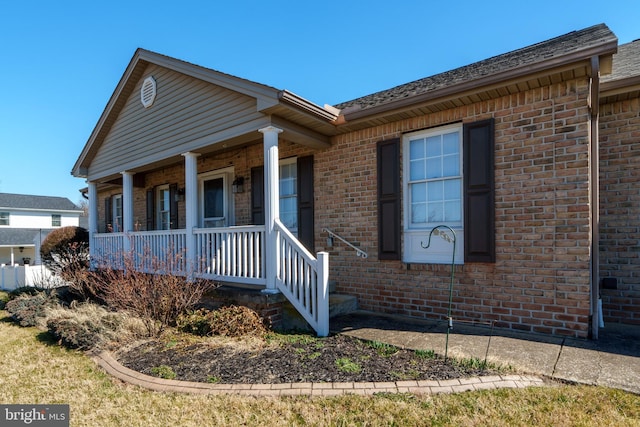 view of front facade with a porch and brick siding