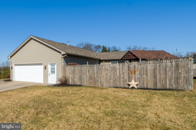 view of home's exterior featuring a yard, fence, driveway, and an attached garage