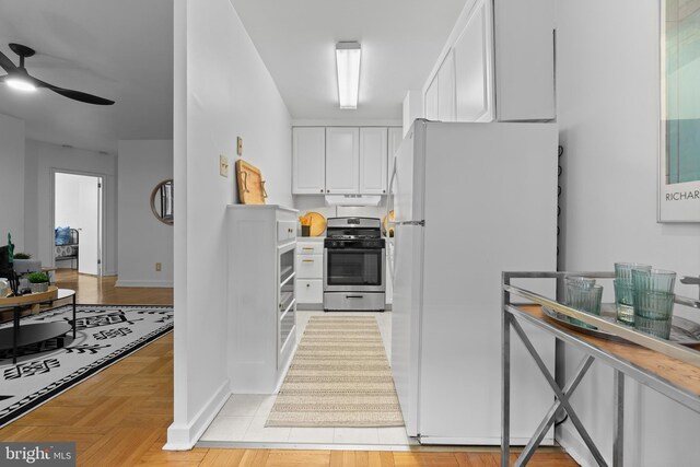 2601 Pennsylvania Ave Unit 952, Philadelphia, PA 19130 - kitchen with freestanding refrigerator, gas stove, white cabinets, ceiling fan, and baseboards