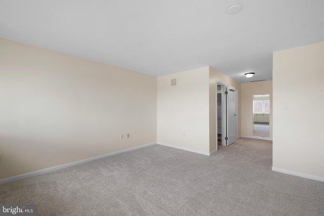 empty room with light carpet and baseboards