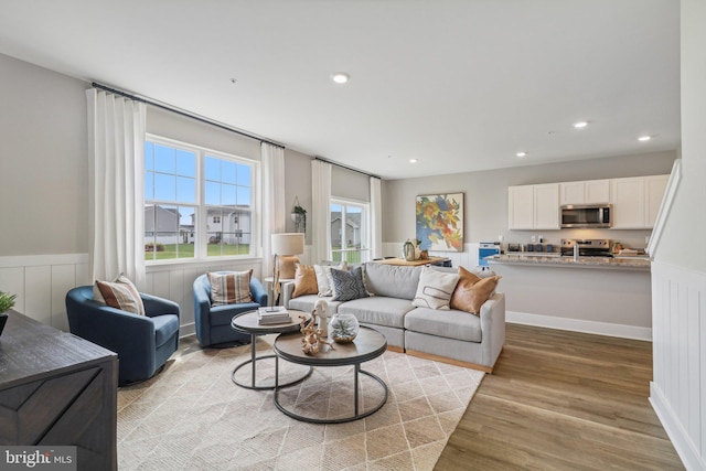 living area featuring wainscoting, light wood-type flooring, and recessed lighting