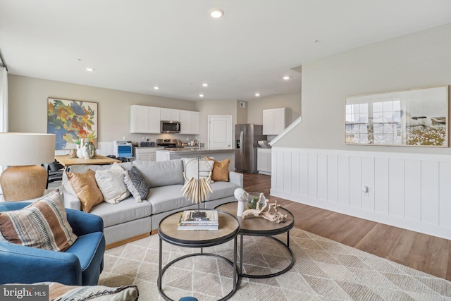 living room with a wainscoted wall, light wood-type flooring, and recessed lighting