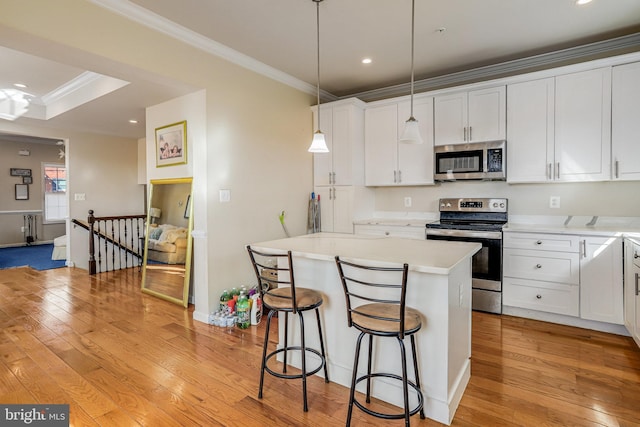 kitchen featuring ornamental molding, appliances with stainless steel finishes, light wood-style flooring, and white cabinetry