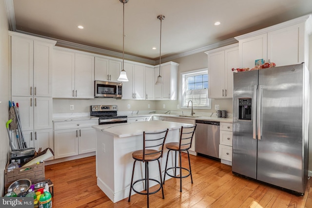 kitchen featuring white cabinets, a kitchen island, stainless steel appliances, and a sink