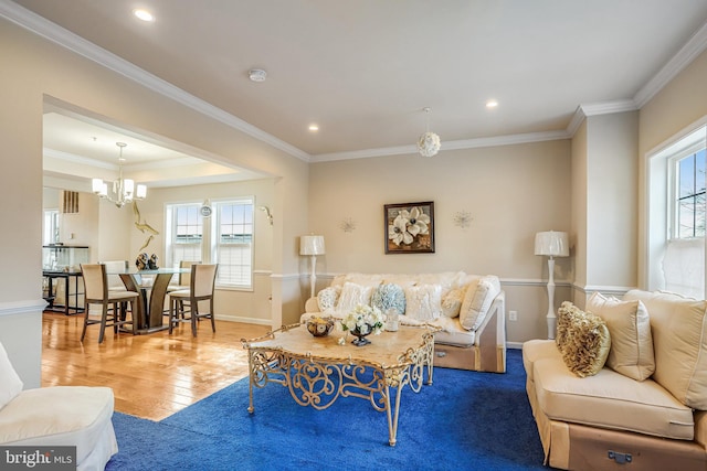 living area with baseboards, hardwood / wood-style floors, and crown molding