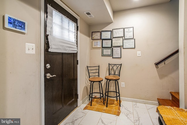 entryway with marble finish floor, stairway, visible vents, and baseboards