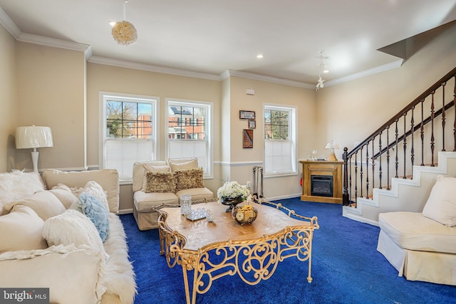 living area featuring ornamental molding, dark colored carpet, a glass covered fireplace, and stairway