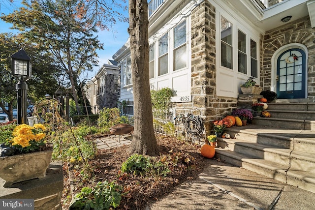 view of side of home featuring entry steps and stone siding