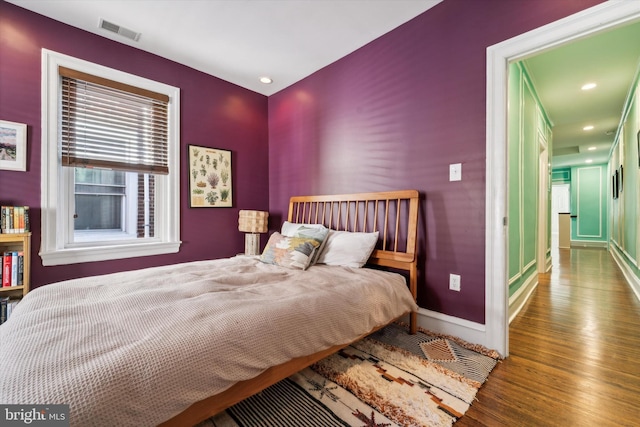 bedroom featuring recessed lighting, visible vents, baseboards, and wood finished floors