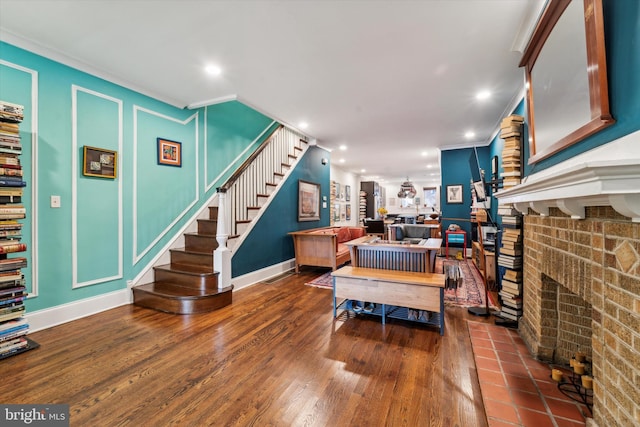 living area with stairway, dark wood-style floors, a fireplace, recessed lighting, and crown molding