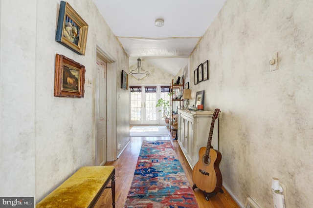 hall featuring vaulted ceiling, wood finished floors, and french doors