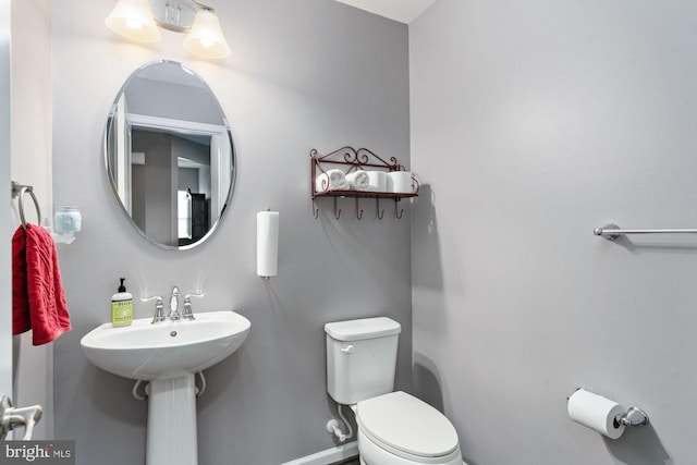 half bath with toilet and baseboards