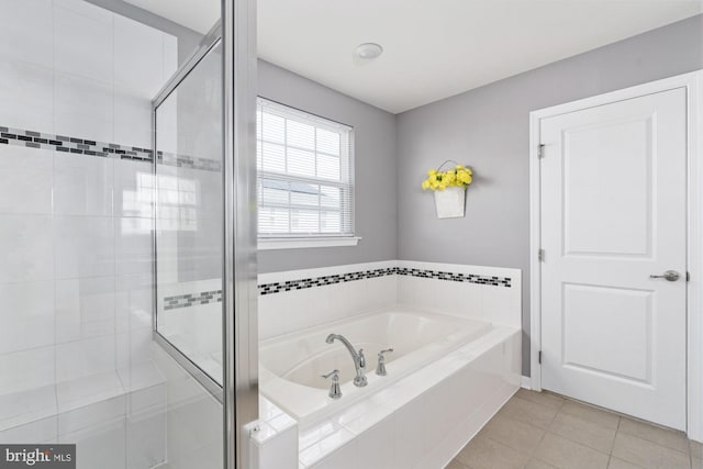 full bathroom featuring a stall shower, a bath, and tile patterned floors