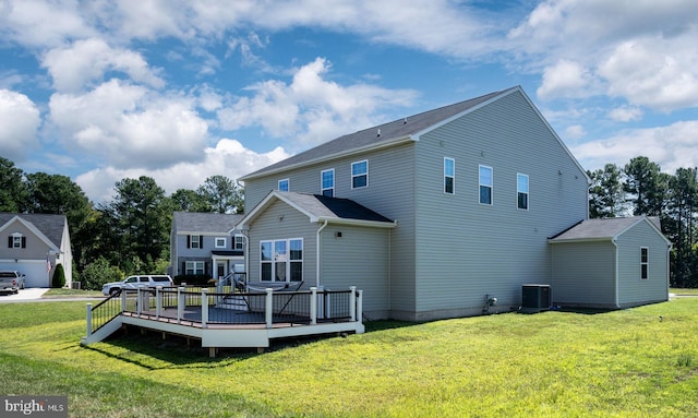 rear view of house with a lawn, a wooden deck, and central AC unit