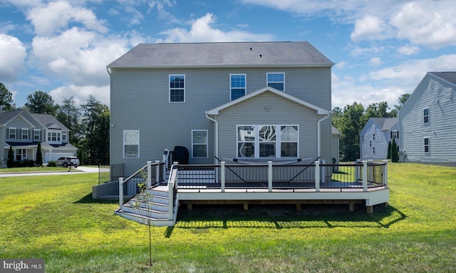 rear view of house featuring a lawn and a wooden deck