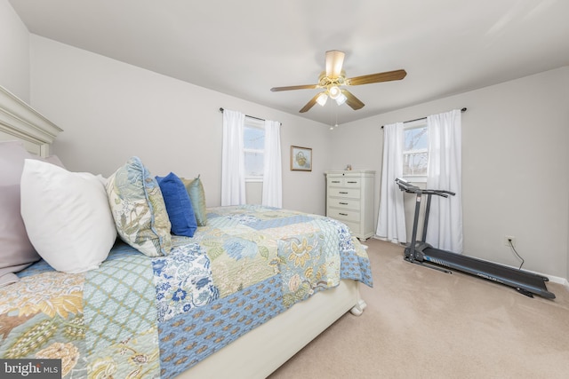 bedroom with a ceiling fan, carpet flooring, and multiple windows