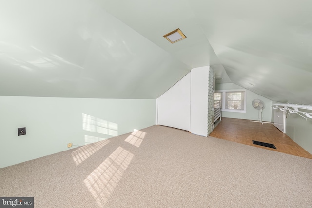 additional living space featuring carpet, visible vents, and vaulted ceiling