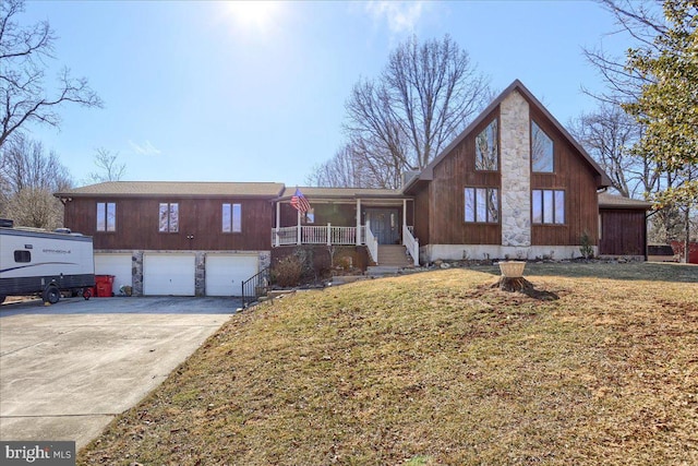 view of front of property featuring an attached garage, covered porch, driveway, and a front lawn