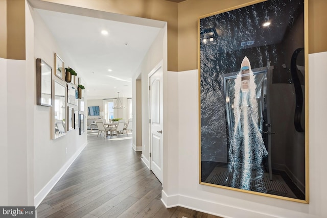 hallway featuring recessed lighting, hardwood / wood-style flooring, and baseboards