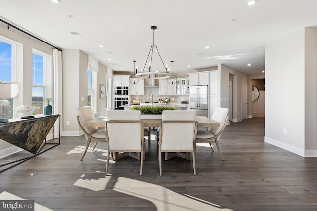 dining room with baseboards, dark wood-type flooring, recessed lighting, and an inviting chandelier