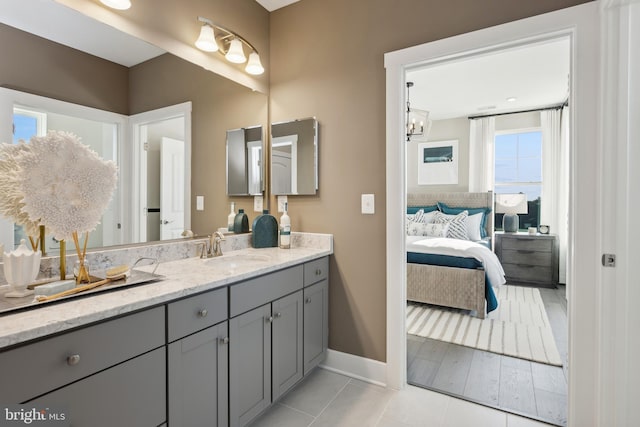 bathroom with ensuite bath, baseboards, tile patterned flooring, and vanity