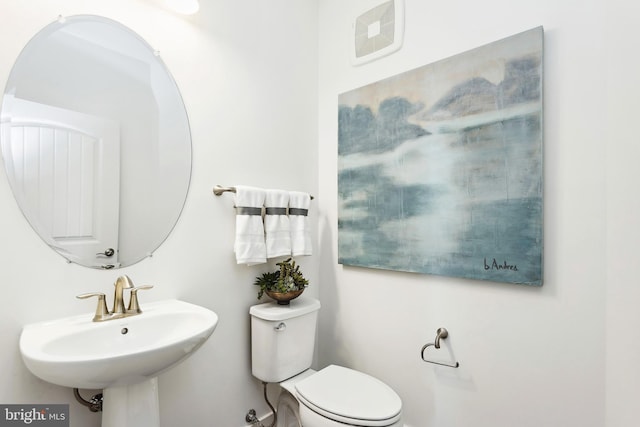 bathroom featuring visible vents, a sink, and toilet