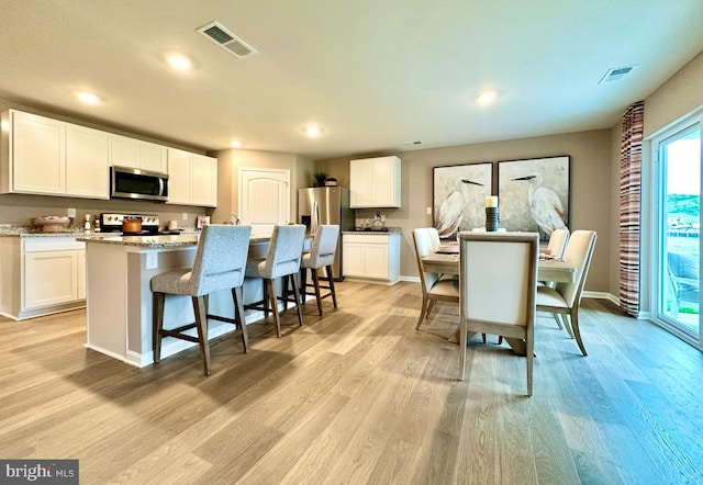 dining area featuring light wood-type flooring, visible vents, and recessed lighting