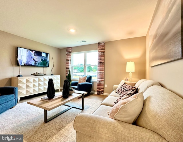 living room with visible vents, baseboards, and wood finished floors