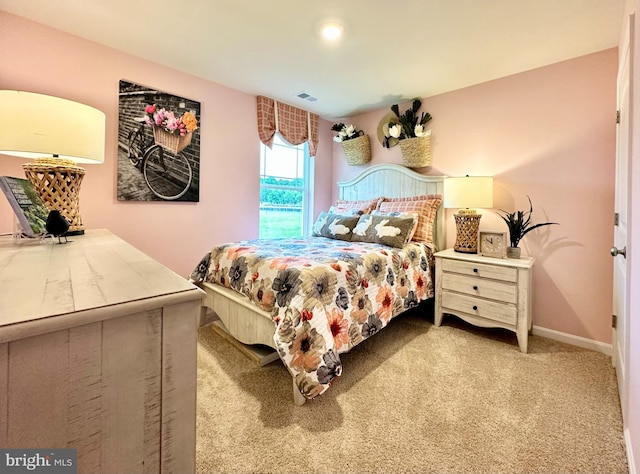 carpeted bedroom with visible vents and baseboards