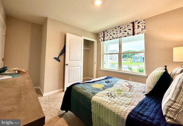 carpeted bedroom featuring a closet and baseboards