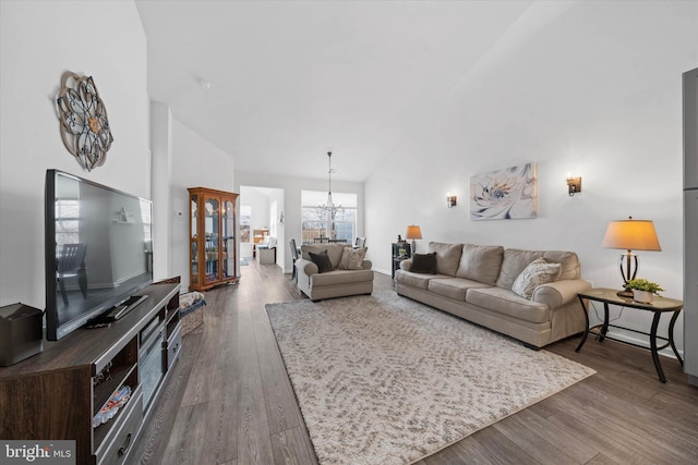 living room with a high ceiling, wood finished floors, and an inviting chandelier