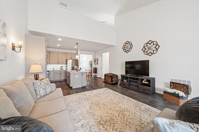 living area featuring dark wood-style floors, visible vents, and recessed lighting