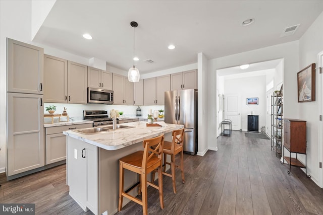 kitchen with stainless steel appliances, dark wood finished floors, a sink, and visible vents