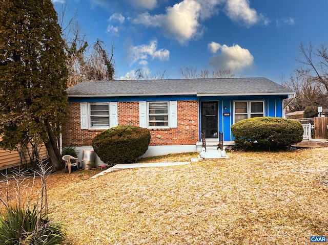 view of front of house featuring fence and brick siding