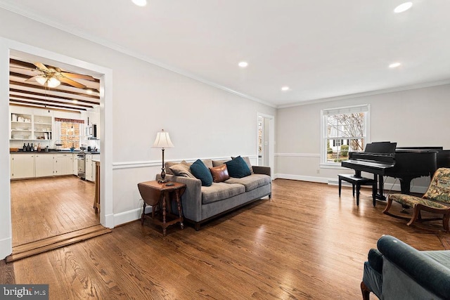 living room featuring recessed lighting, baseboards, wood finished floors, and crown molding