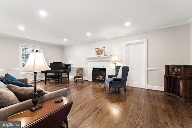 living room with recessed lighting, a brick fireplace, wood finished floors, and ornamental molding