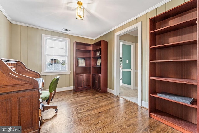 office space featuring visible vents, built in shelves, ornamental molding, wood finished floors, and baseboards