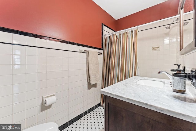 bathroom featuring toilet, curtained shower, tile walls, and vanity